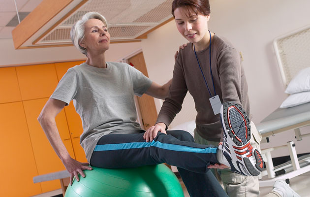 Terapeuta guando a paciente en su rutina para mejorar su fuerza para aliviar el dolor de rodilla