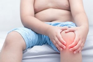 Paceinte con hoffitis de rodilla sosteniendo su rodilla por dolor